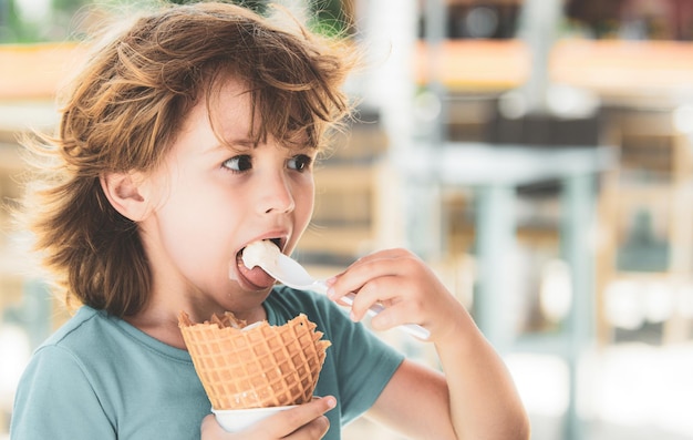 Portrait d'un enfant drôle mangeant une glace savoureuse