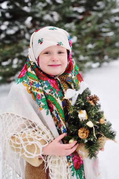 Portrait d'une enfant fille dans un foulard dans le style Urs à la surface de la neige et de la forêt