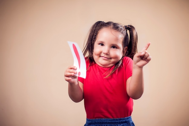 Portrait D'enfant Fille Tenant La Carte Avec Point D'exclamation. Les Enfants Et Le Concept De L'éducation