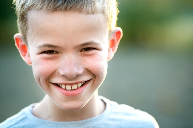 Portrait d'un enfant garçon à l'extérieur sur une chaude journée d'été ensoleillée.