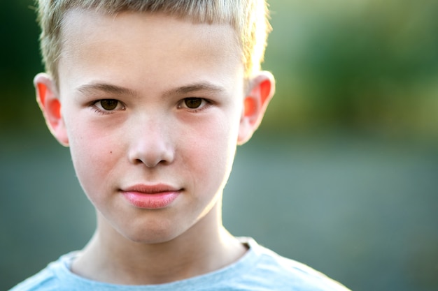 Portrait d'un enfant garçon à l'extérieur sur une chaude journée d'été ensoleillée.