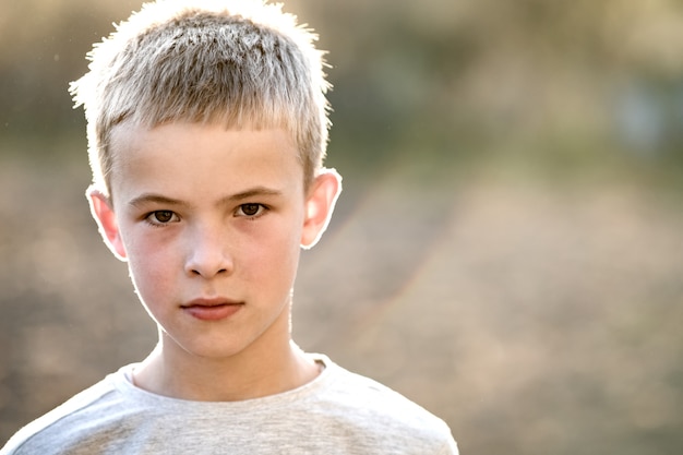 Portrait d'un enfant garçon à l'extérieur sur une chaude journée d'été ensoleillée.