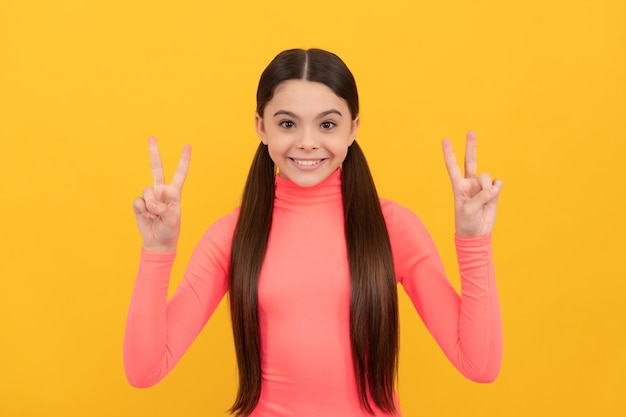 Portrait d'enfant heureux exprimer des émotions positives paix saine de la peau et des cheveux