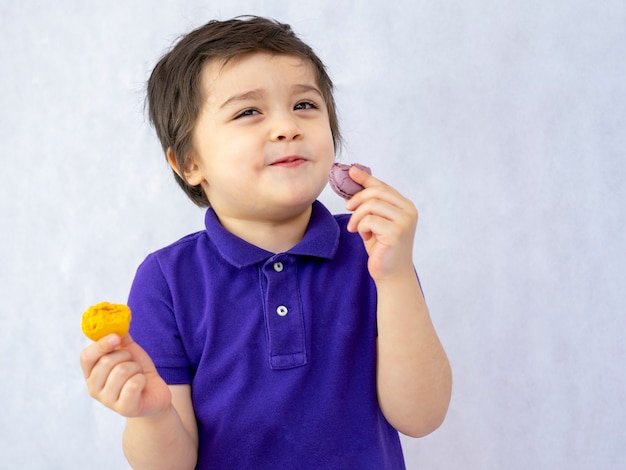 Portrait d'un enfant heureux de manger des macarons