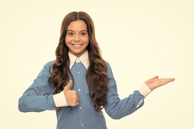 Portrait d'enfant heureux présentant le produit montrant le pouce vers le haut de la publicité de l'espace de copie