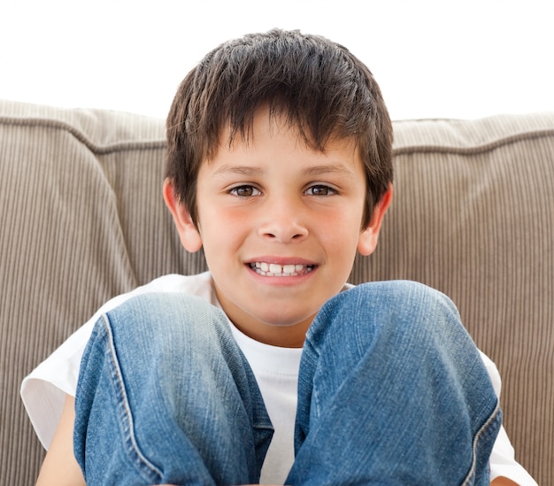 Portrait d&#39;un enfant heureux reposant sur le canapé