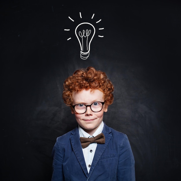 Photo portrait d'un enfant intelligent avec une ampoule