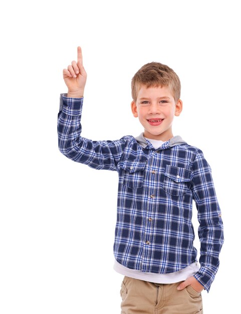 Portrait d'enfant et main pointant vers l'espace d'idées avec un sourire optimiste amical et heureux pour la publicité Bonheur mignon et jeune enfant présentant une maquette pour le marketing sur fond blanc isolé