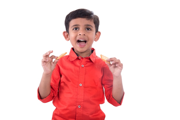 Portrait d'enfant mangeant un biscuit sur fond blanc