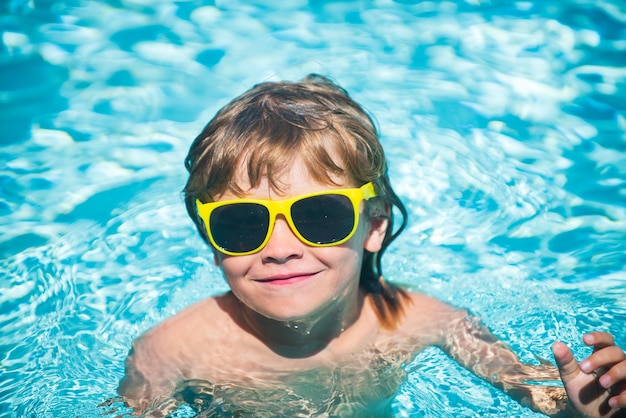 Portrait d'enfant mignon s'amusant dans la piscine