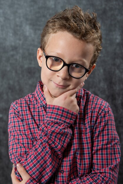 Photo portrait d'enfant mignon songeur avec chemise à carreaux