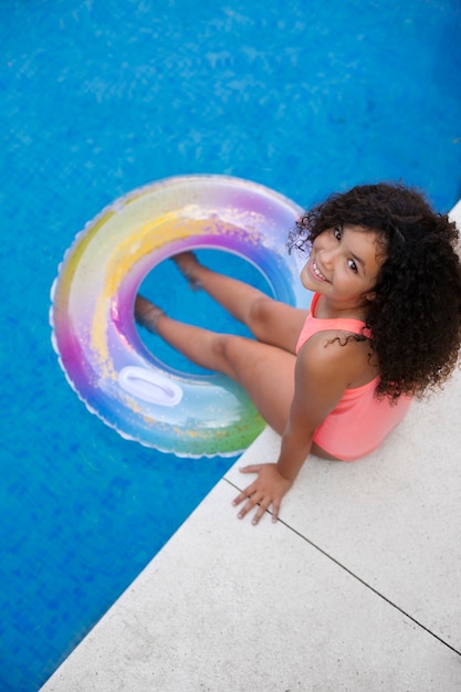 Photo portrait d'enfant à la piscine avec flotteur