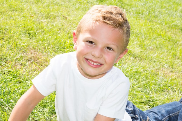 Portrait d'enfant souriant à l'extérieur. Garçon regardant la caméra avec un beau sourire sur son visage