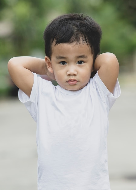 Portrait des enfants asiatiques debout en plein air et en regardant le contact des yeux à la caméra