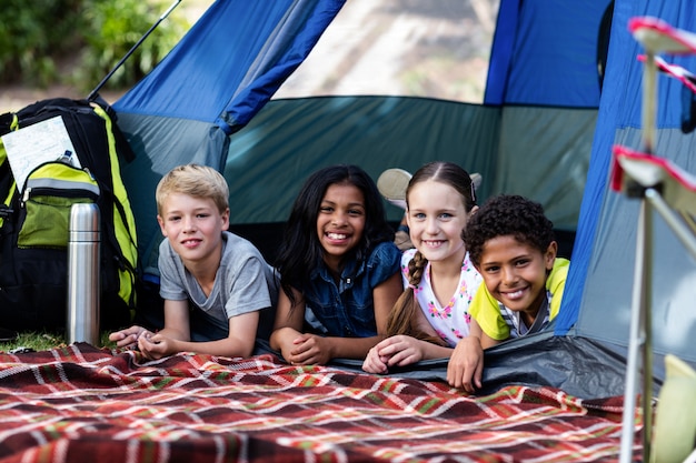 Portrait d'enfants couchés dans une tente
