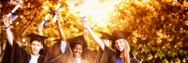 Portrait d'enfants de l'école doctorale debout avec défilement de diplôme sur le campus