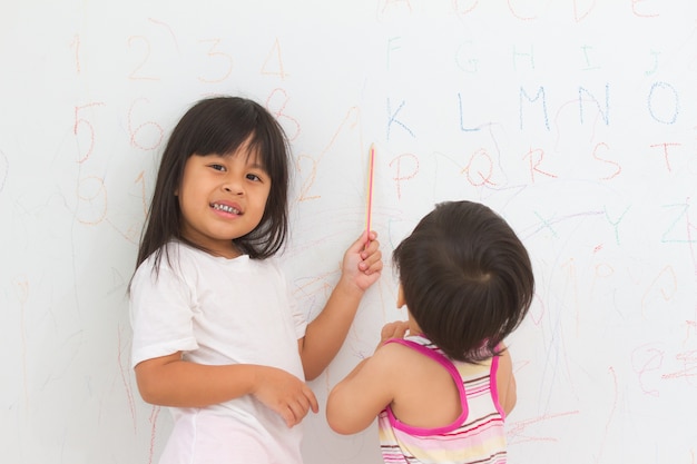 Portrait d&#39;enfants écrivant sur le mur