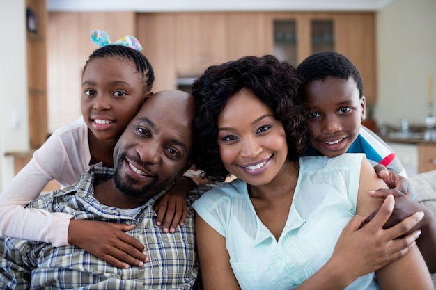 Portrait d'enfants embrassant leurs parents dans la salle de séjour