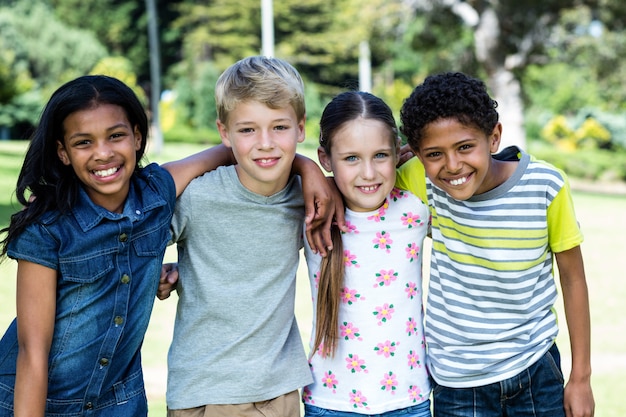 Portrait d'enfants heureux debout ensemble dans le parc