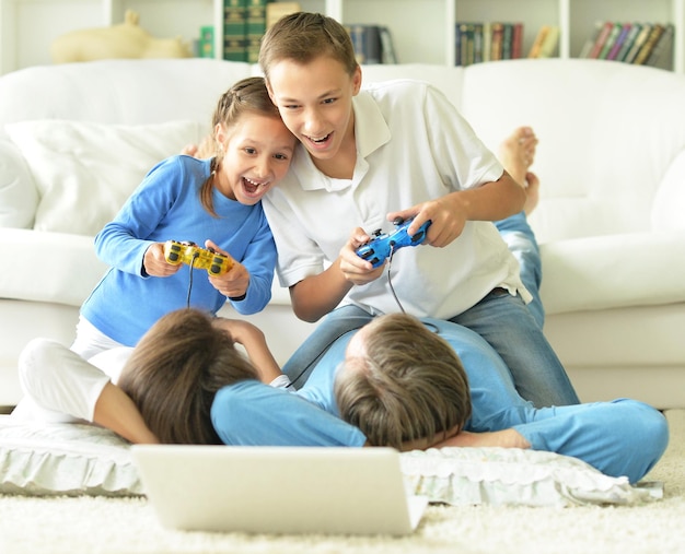 Portrait d'enfants jouant à des jeux informatiques à la maison