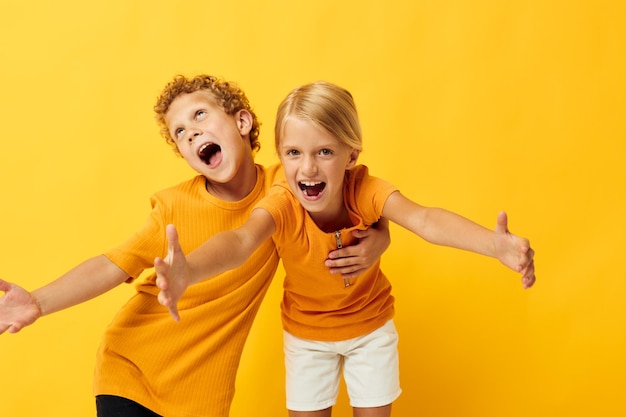 Portrait d'enfants mignons câlins mode enfance divertissement fond jaune inchangé