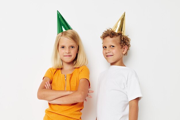 Portrait d'enfants mignons posant des émotions vacances casquettes colorées fond clair