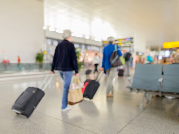 Portrait de l'enregistrement de départ du terminal défocalisé à l'aéroport avec les voyageurs à pied