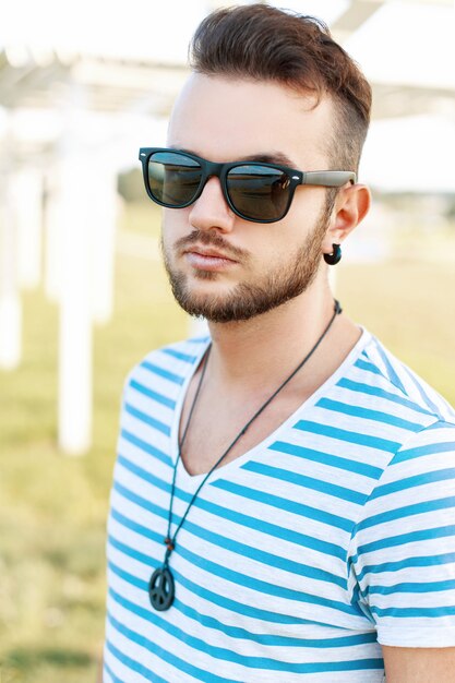 Portrait ensoleillé d'un bel homme avec une barbe sur la plage.