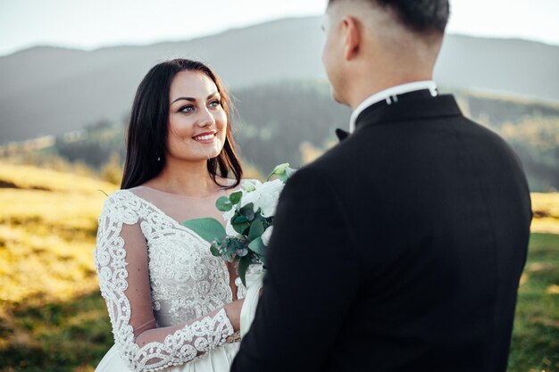 Portrait ensoleillé de la mariée et du marié heureux en plein air dans la nature au coucher du soleil