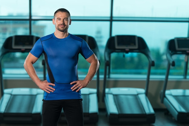 Portrait d'un entraîneur personnel en tenue de sport dans la salle de sport du centre de remise en forme