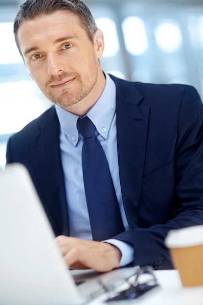 Portrait d'une entreprise ou d'un homme d'affaires avec un ordinateur portable pour la stratégie d'investissement, la croissance financière ou la réussite financière Personne de sexe masculin PDG ou directeur au bureau dans la planification de l'analyse des données ou de l'analyse de l'économie