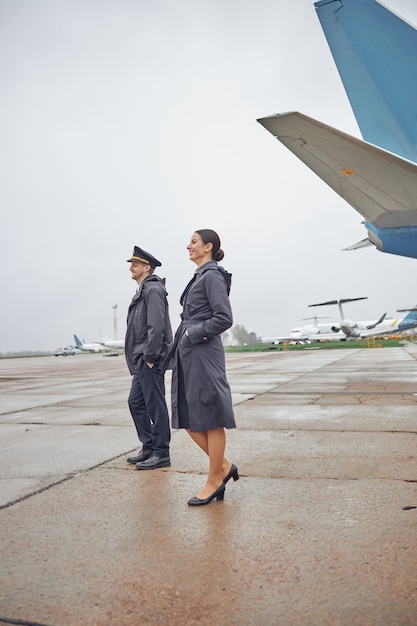 Portrait d'équipage d'avion caucasien heureux et confiant près de l'avion