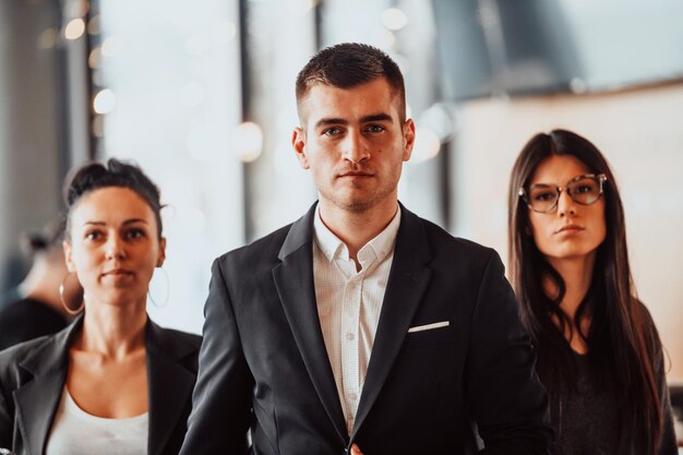 Portrait d'une équipe commerciale créative réussie regardant la caméra et souriant. Divers groupes de gens d'affaires se tenant ensemble dans un bureau de coworking de démarrage.