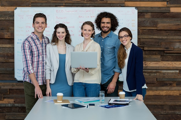 Portrait de l'équipe commerciale souriante à l'aide d'un ordinateur portable