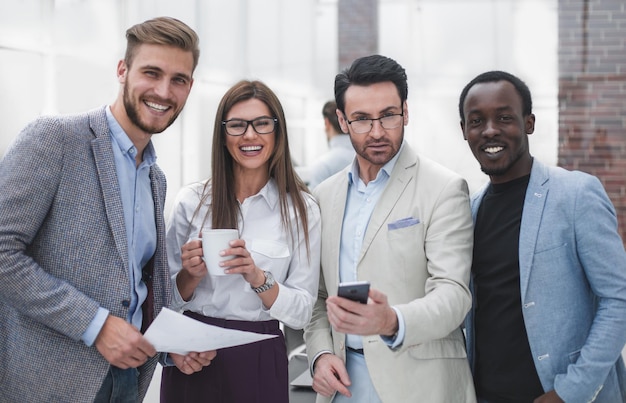 Portrait d'une équipe commerciale souriante sur fond de bureau