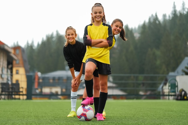 Un portrait d'une équipe de football féminine heureuse ensemble sur le terrain du stade