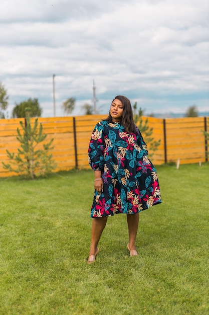 Portrait d'été d'une belle femme afro-américaine en robe colorée, debout sur un sous-sol d'arrière-cour