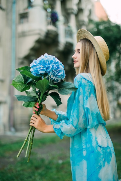 Portrait d'été d'une belle femme marchant dans les rues avec des fleurs d'hydragea