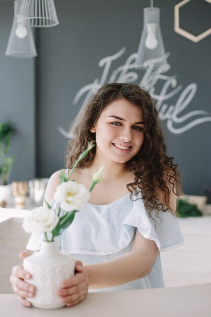 portrait d'été d'une belle fille romantique dans une robe à l'intérieur