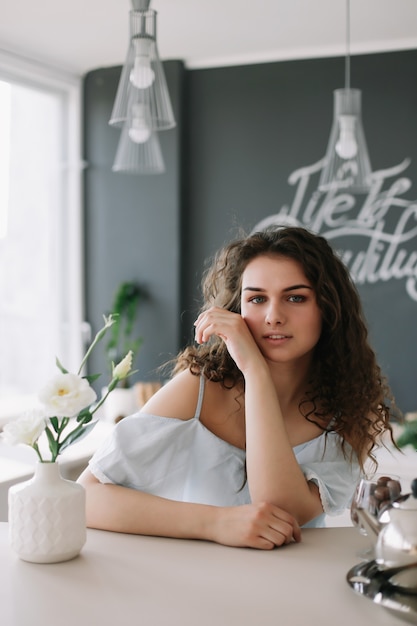 portrait d'été d'une belle fille romantique dans une robe à l'intérieur