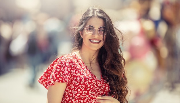 Portrait d'été d'une belle jeune femme dans la ville avec le vent dans les cheveux