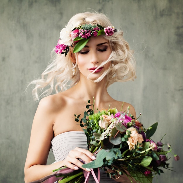 Portrait d'été de femme modèle blonde parfaite aux cheveux bouclés et couronne de fleurs