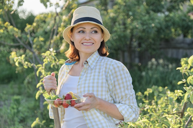 Portrait d'été en plein air de femme positive mature en chapeau de paille sur la nature