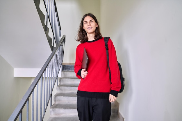 Portrait d'un étudiant adolescent avec un sac à dos pour ordinateur portable regardant la caméra