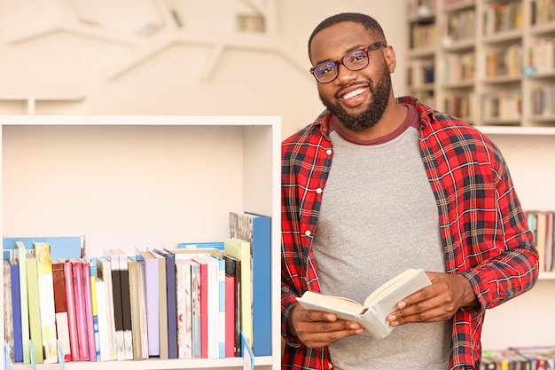 Photo portrait d'étudiant afro-américain en bibliothèque