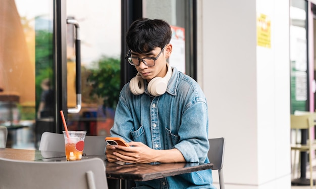 Portrait d'un étudiant asiatique assis dans un café