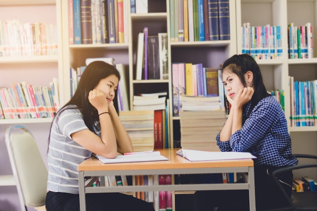 Portrait d&#39;étudiant asiatique intelligent lire et faire des recherches dans la bibliothèque du collège