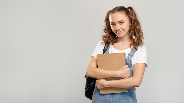 Portrait d'étudiant heureux Retour à l'école Adolescente joyeuse et confiante avec sac à dos pour ordinateur portable souriant isolé sur fond d'espace vide neutre Publicité de cours