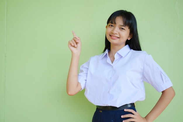 Portrait étudiant jeune fille à l'école uniforme sur fond vert, fille asiatique, adolescente.