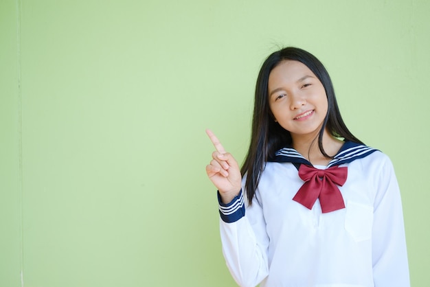 Portrait étudiant jeune fille à l'école uniforme sur fond vert, fille asiatique, adolescente.